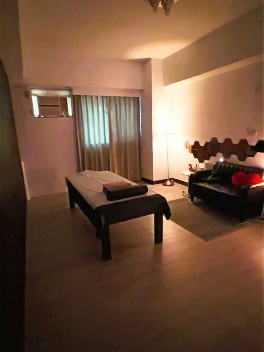 按摩的房間內有沙發、桌子和燈具，營造出舒適的氛
