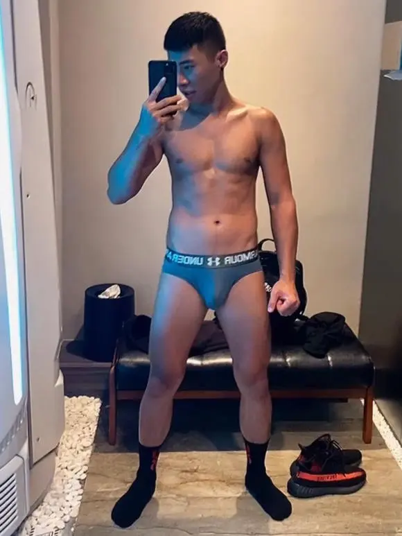 台北同志按摩師Kevin穿著內褲在鏡子前自拍，展現自信的姿態