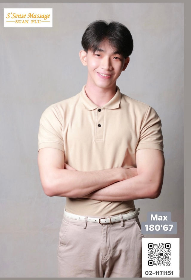 Smiling person in a beige polo and pants stands confidently with arms crossed, promoting S'Sense Massage Suan Plu, a trusted gay massage Bangkok destination. QR code and text details included.