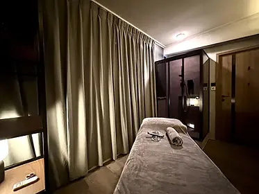 Massage room at AK Spa HK, featuring a bed and curtains, offering a relaxing ambiance for men's gay massage in Hong Kong.