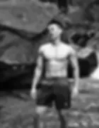 A black and white photo of KAI, a handsome and muscular therapist from Star Nagoya, standing shirtle