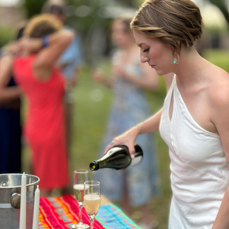 Bride pouring champagne after her elopement wedding ceremony at a farm venue near Tucson, Arizona