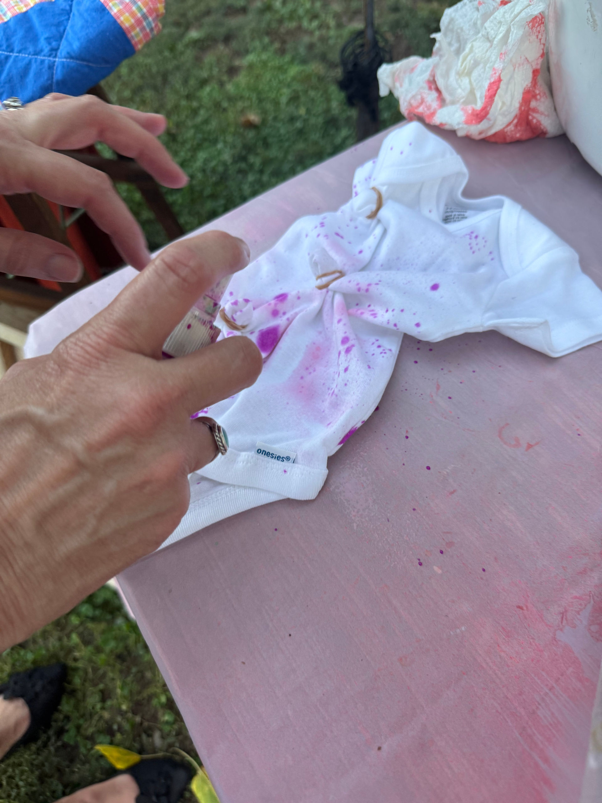 At a garden baby shower near Tucson, Arizona, guests tie-dyed onsies for the baby