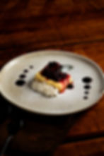 Cheesecake con salsa de frutos rojos en plato blanco