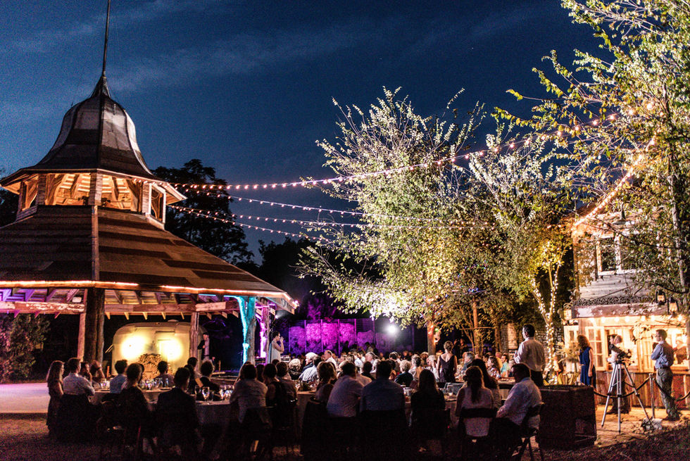 seated party guests next to dramatic pavilion at night