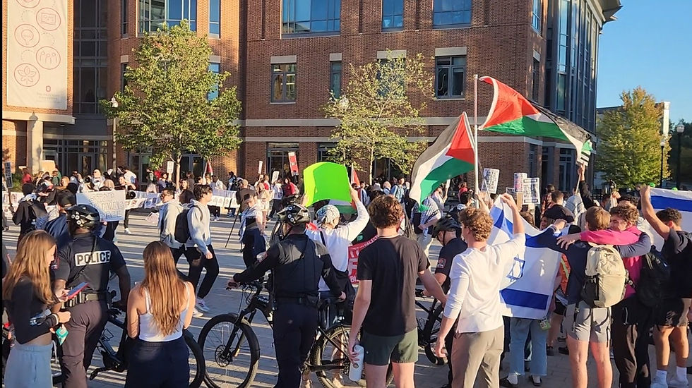 Pro-Palestinian student protesters stand outside the Ohio Union, holding names of Palestinians who died; police stand between them and pro-Israel counterprotesters, October 7, 2024. (Fin414791 via Wikimedia Commons)