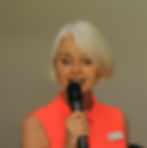 Woman in orange dress holding microphone