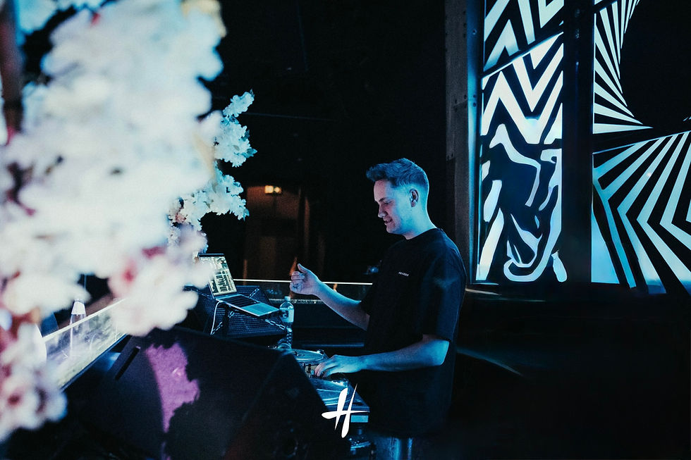 DJ Tom Dean beim Auflegen in einem Club mit blauem Licht