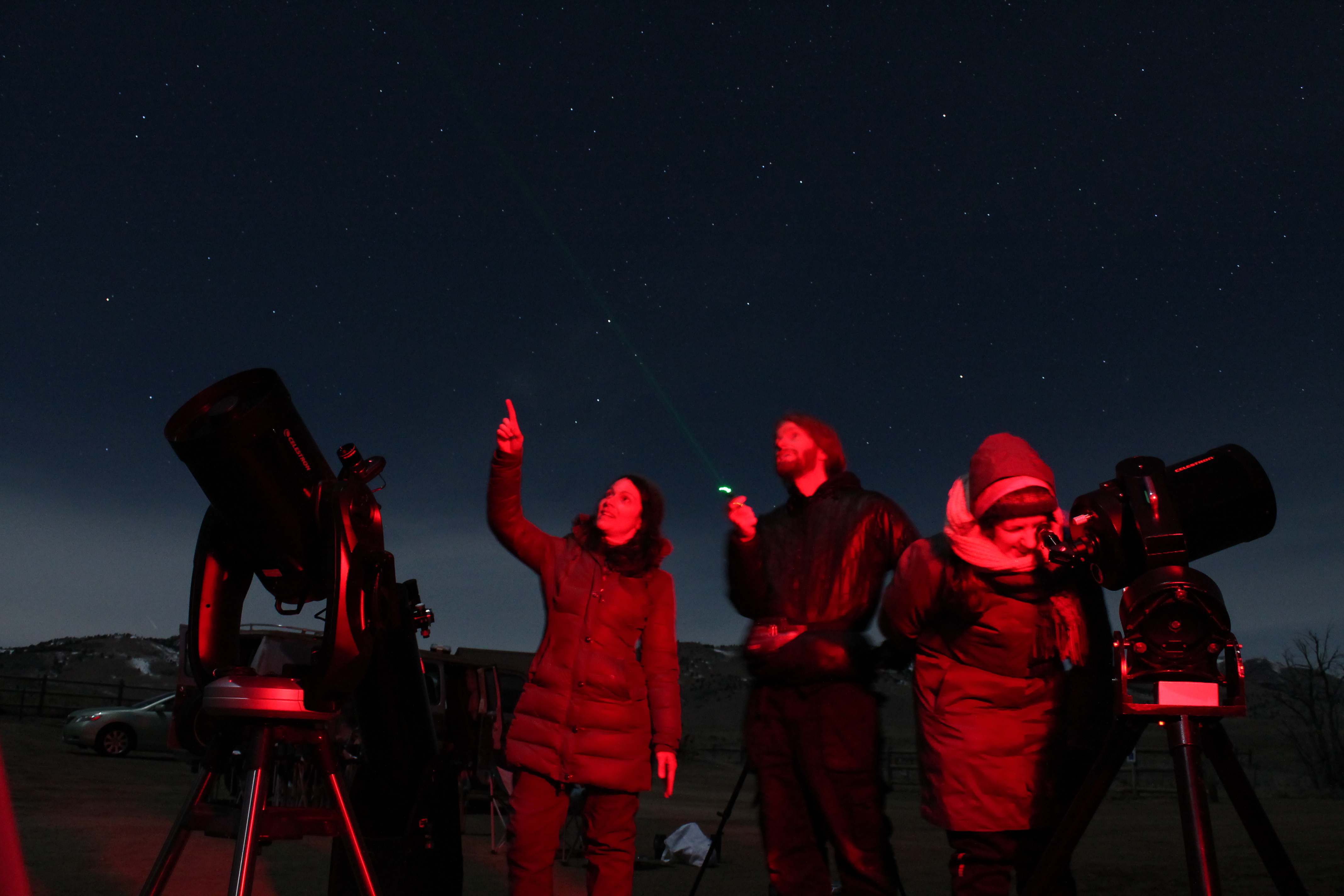 Guests gathered around AstroTours telescopes during a guided night-sky program in Colorado