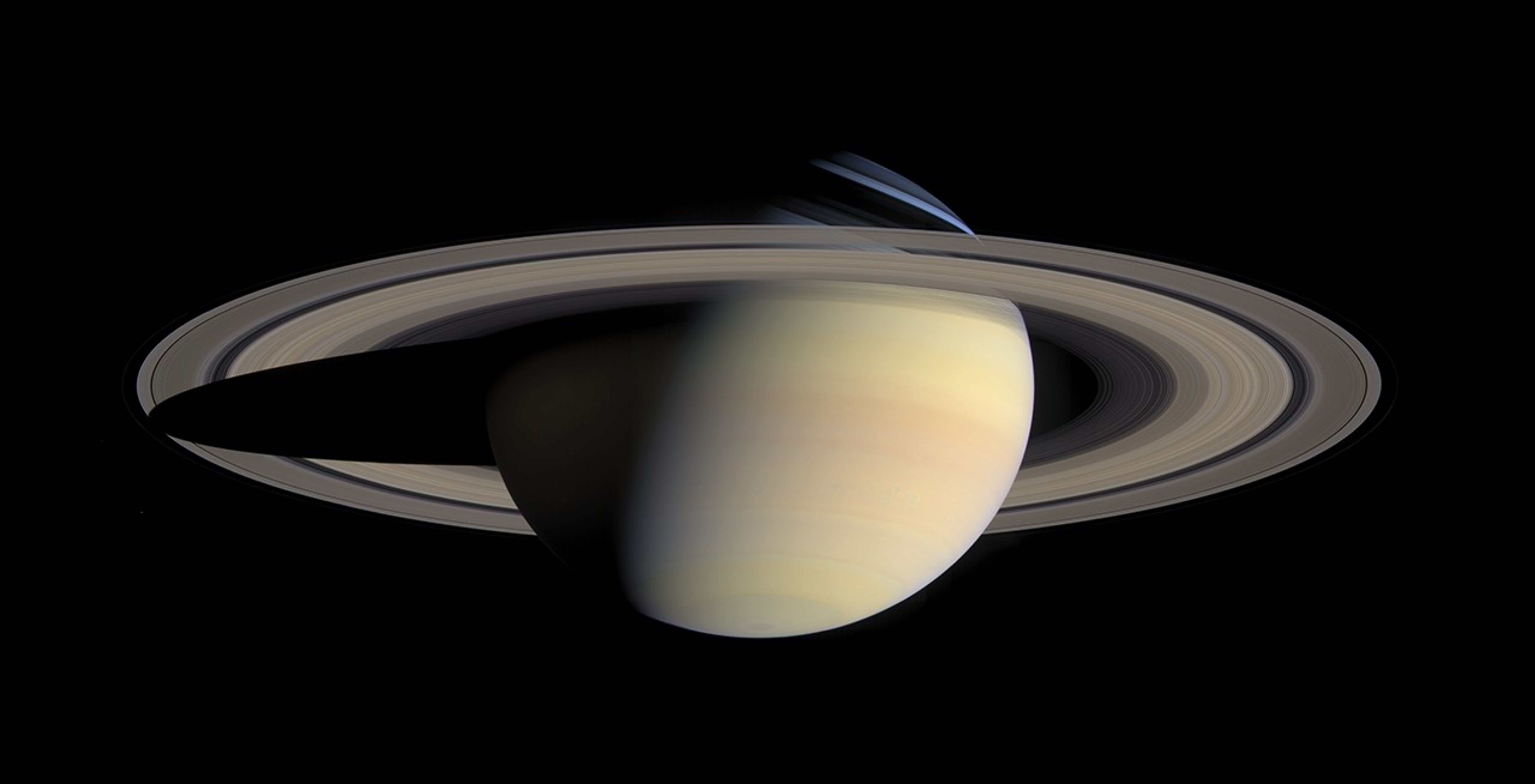 Cassini natural-color mosaic of Saturn and its rings, with ring shadows across the globe.