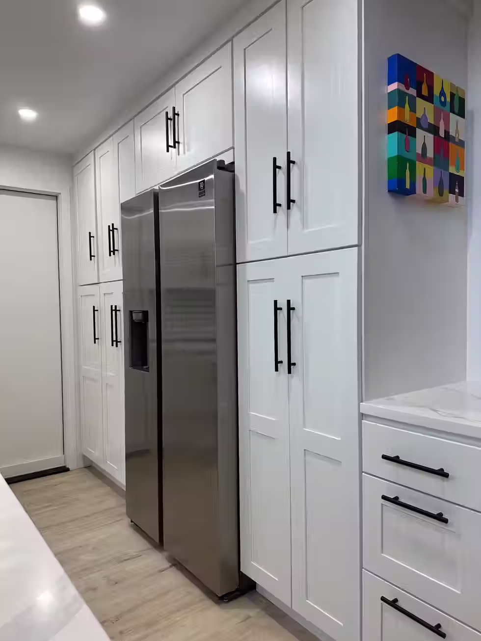 Custom kitchen in Bellevue a kitchen with white cabinets and a stainless steel refrigerator