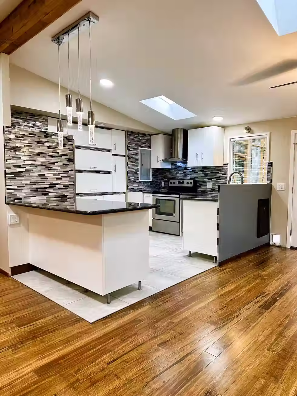 Modern kitchen with white cabinets, mosaic tile backsplash, stainless steel appliances, and pendant lighting in West Seattle remodel

