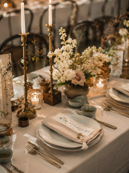East Meets West wedding tablescape with Chinese calligraphy menus, candlelight, soft florals, celadon ceramics, and Western luxury place settings.