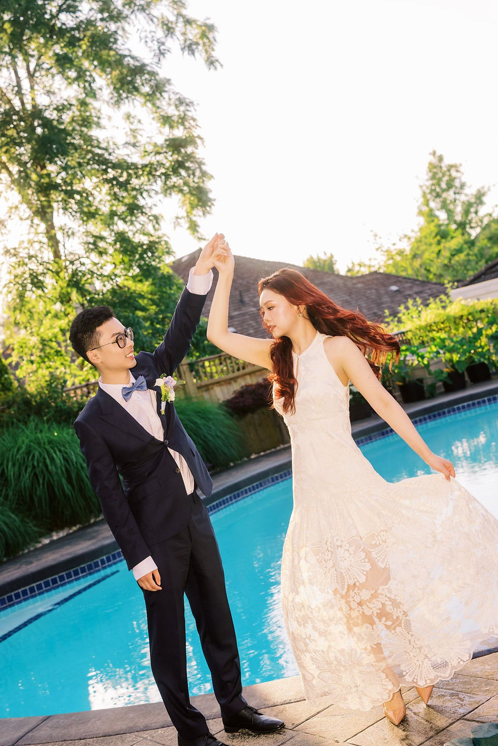 Bride and groom laughing together in a flower-filled backyard during an intimate home wedding in Vancouver