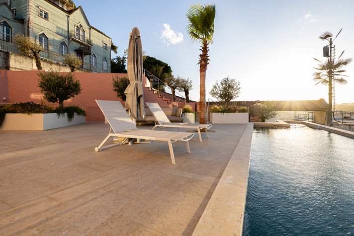 Fotografia exterior de moradial de luxo com piscina em Lisboa ao pôr do sol