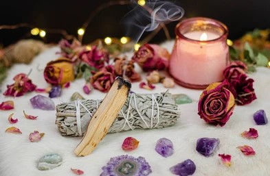 sage and palo santo, surrounded by crystals and dried flowers, candles
