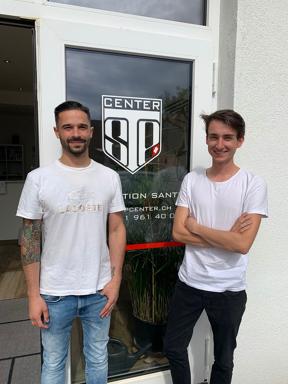 Thibaut Amand physiothérapeute et Sébastien Bard ostéopathe posent devant l'entrée du centre swiss talent project center