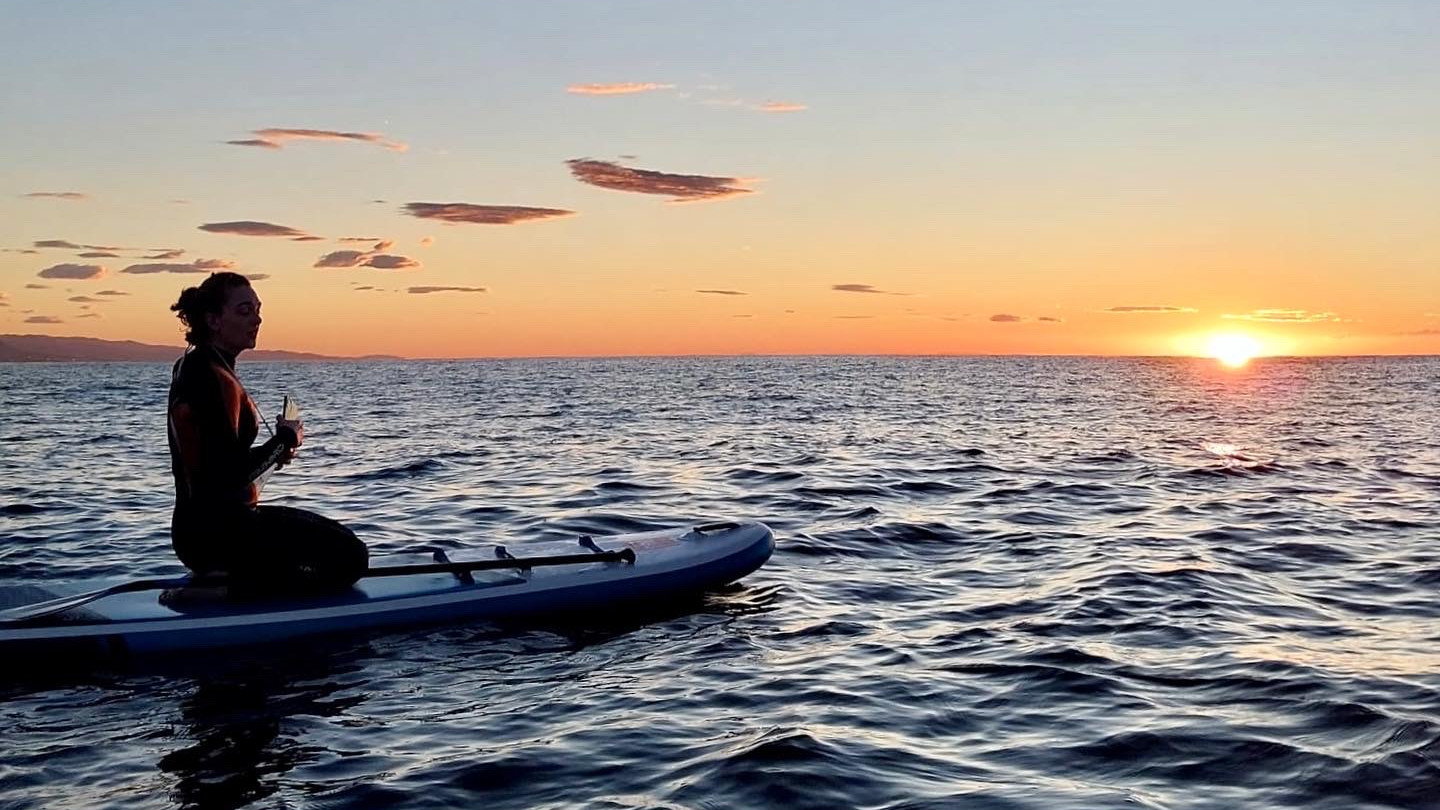 Paddleboarding at sunrise in the Balearic Sea off the coast of Barcelona, Spain.