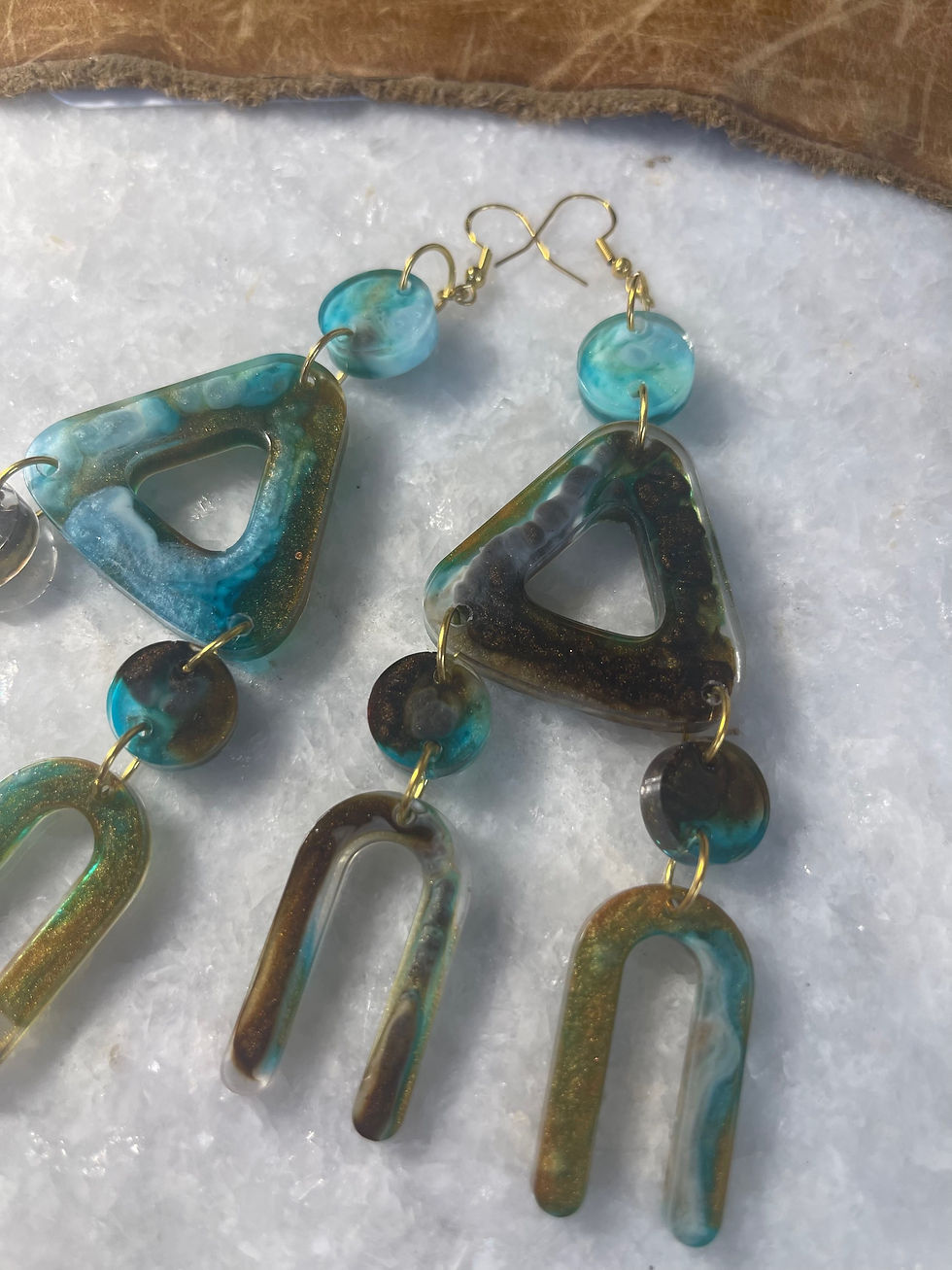 Thumbnail: Handmade resin and metal earrings. Blues, browns and whites swirled 