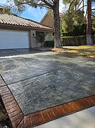 New stamped concrete driveway with two colors and a decorative brick-pattern border, installed by VIP Concrete at a residential home