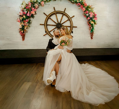 bride is siting on groom's lap taking photo