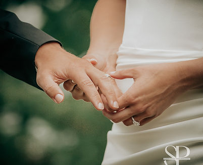 bride is putting groom's wedding ring on his finger