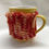 Thumbnail: Knitted Mug Cosy - Red and Orange