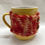 Thumbnail: Knitted Mug Cosy - Red and Orange