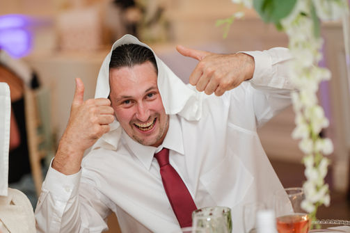 Wedding guest in a white shirt and red tie giving two thumbs up at Hythe Imperial Hotel.