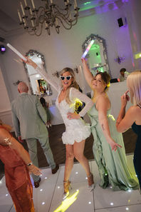 Bride and guests dancing with their arms raised at Hythe Imperial Hotel, Kent.
