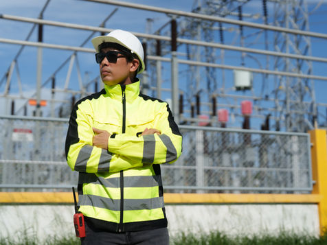 Electrical engineer wearing high visibility yellow arc-rated workwear