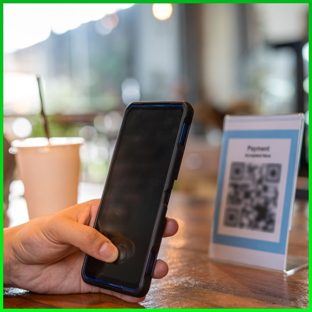 A person scanning QR code in coffee shop