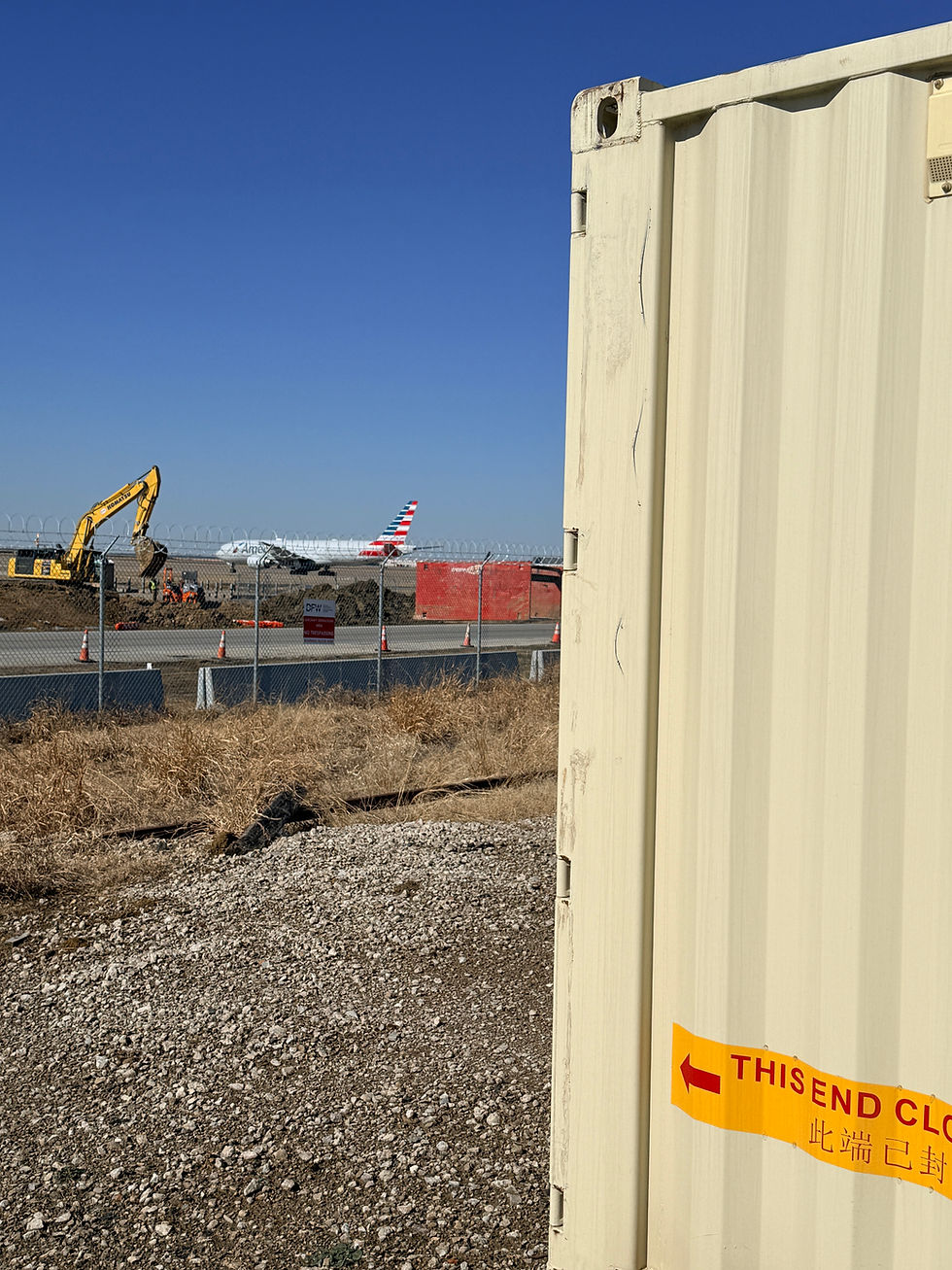 Partial light container, American Airlines plane, excavator background.