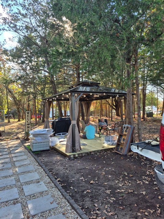 Outdoor gazebo with seating, trees, and string lights, 4 Rivers Hideaway