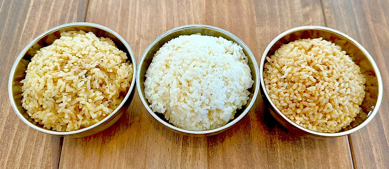 Three bowls of rice: brown, white, and yellow