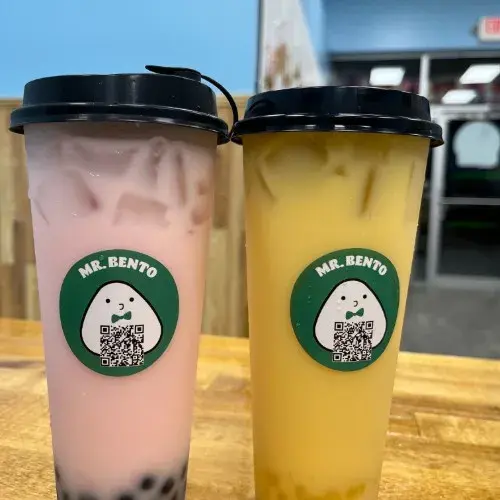 两杯奶茶，上面有 Mr. Bento 标志 ，珍珠奶茶美味，色彩鲜艳