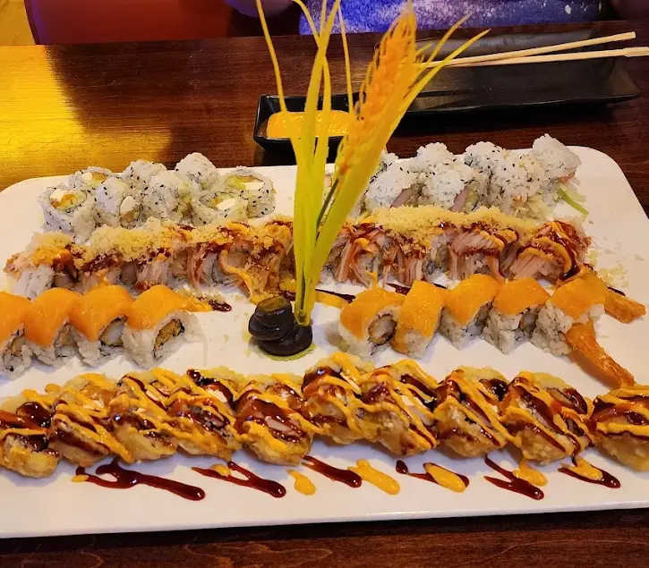 Various sushi rolls beautifully arranged on a white platter at Kamiya Sushi restaurant.