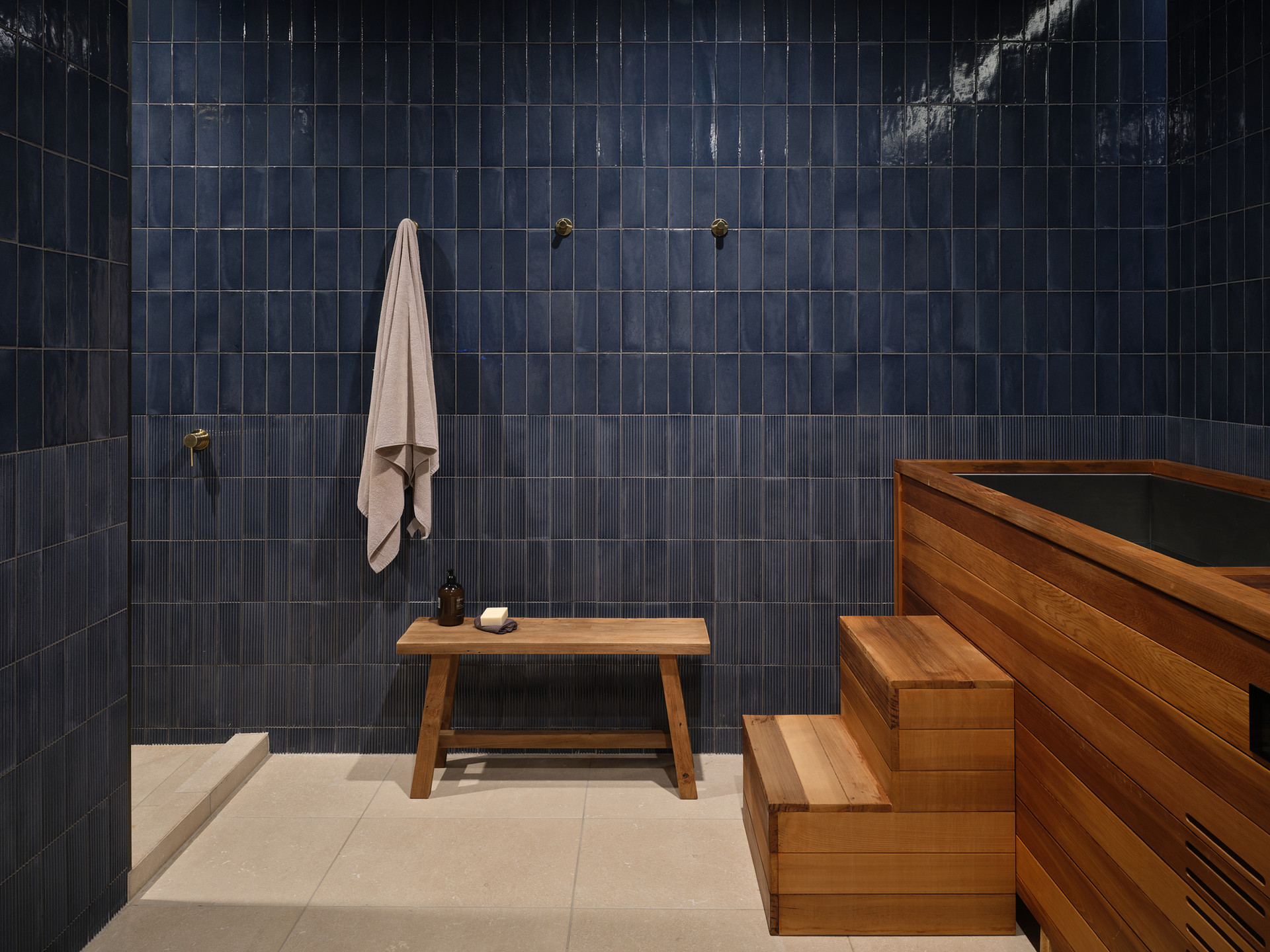 The navy tiled contrast therapy room with cedar plunge at Boon Wellness