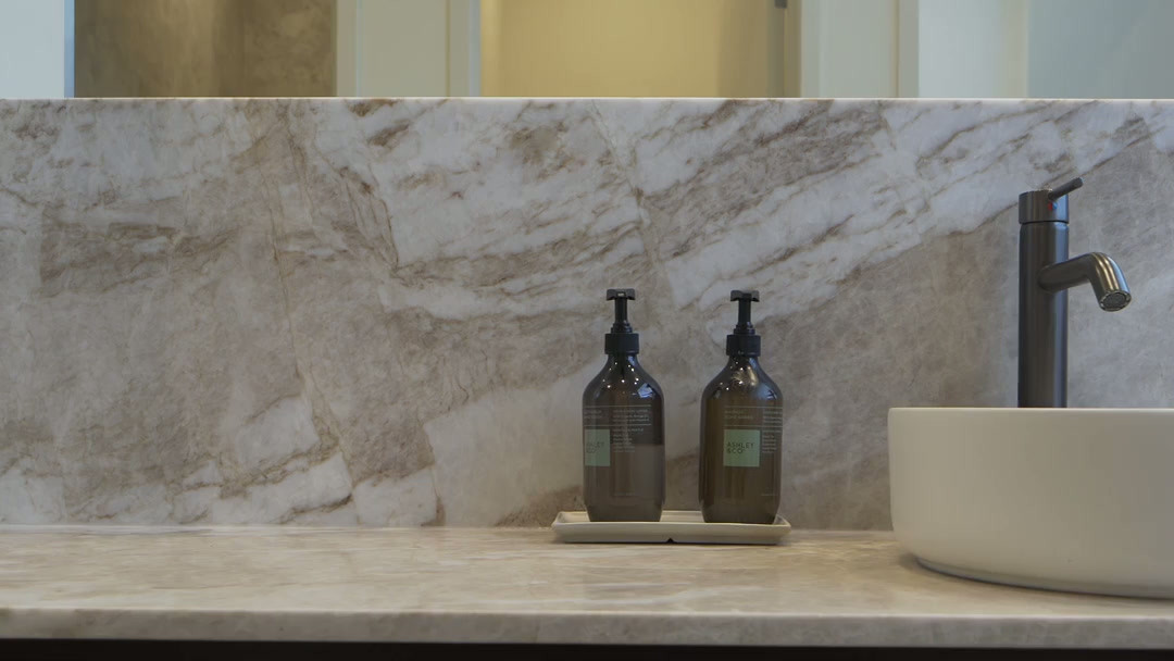 A marble vanity with basin and amber bottles inside Twenty Two Mokoia