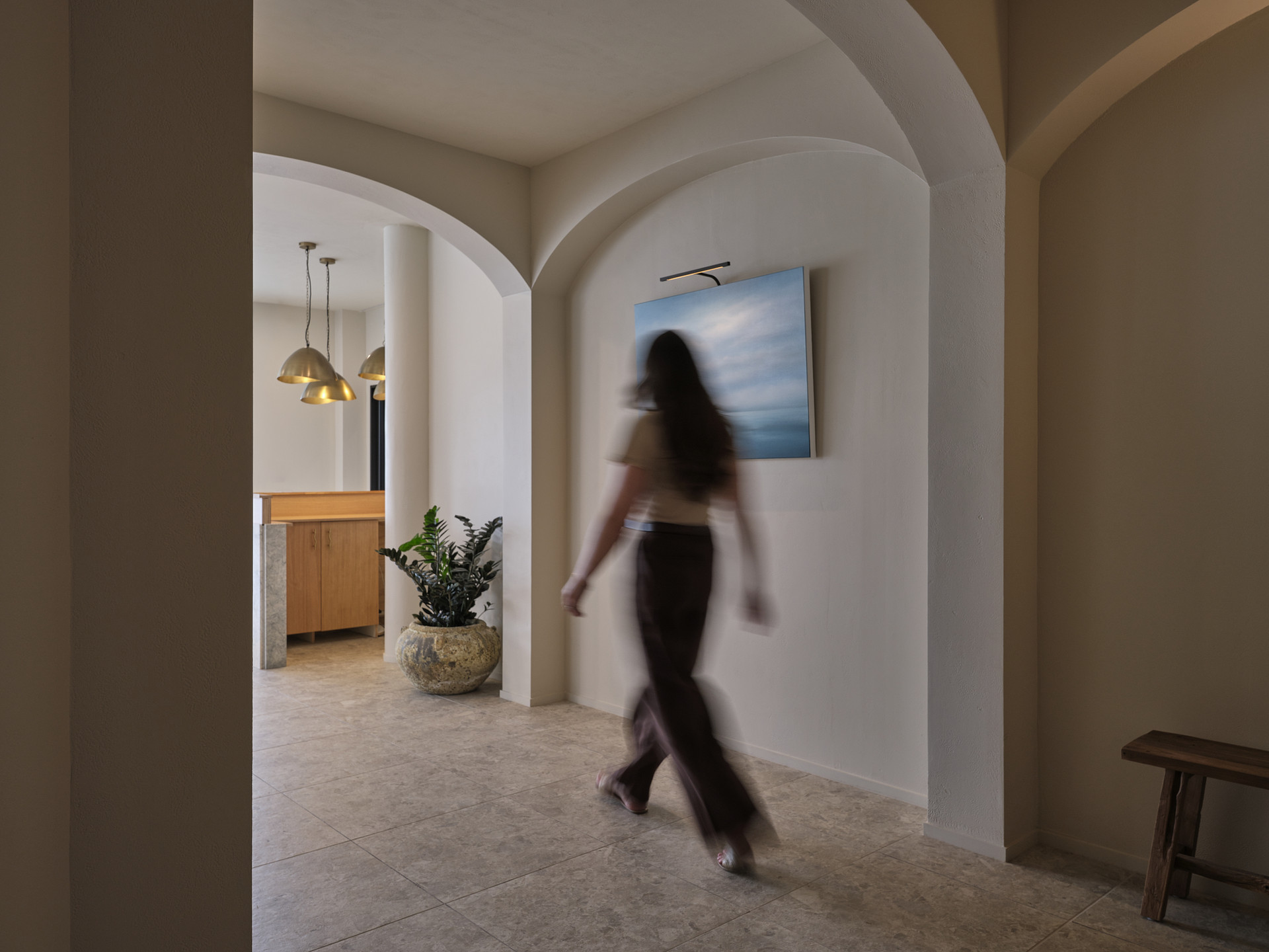 A visitor walking through the arched corridor toward reception at Twenty Two Mokoia