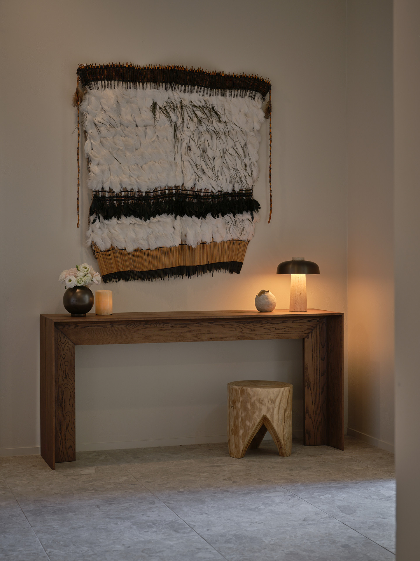 An oak console beneath a woven wall hanging inside Twenty Two Mokoia