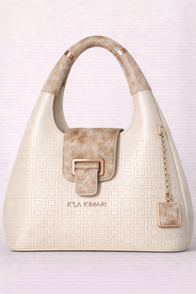 white luxury handbag egg shaped, gold and blond hide hair handle and matching flap closure and gold chain tassle, embossed