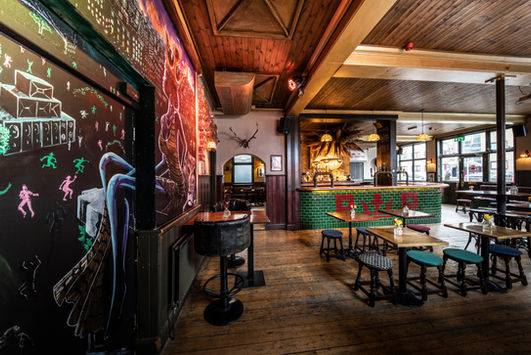 Tables, stools, bar and chalkboard at the Prince of Peckham, black owned independent pub South East London.