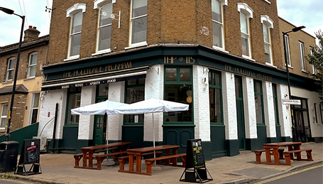 Facade with tables, benches and parasol at the Hollydale, independent pub in Peckham, South East London.