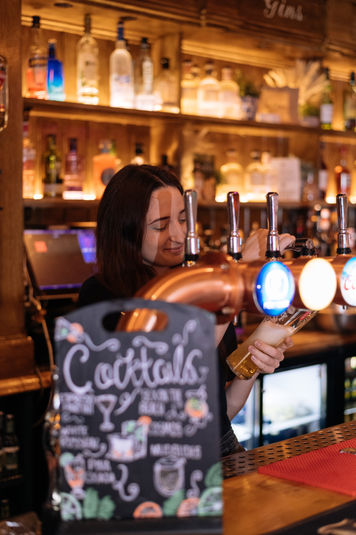 Staff pouring beers at the Old Hat, Ealing independent pub in West London.