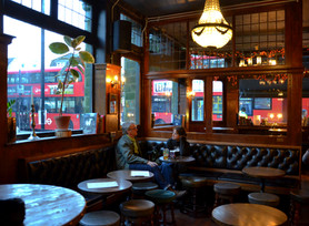 Customers on benches with tables and stools at the Alpaca, independent pub in Islington, North London.