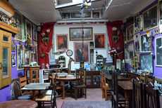 First floor with tables, chairs, frames on walls at the Prince of Greenwich, independent Greenwich pub in London.