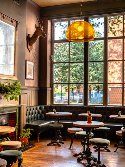 Tables, bench, stools and lamp at the Roebuck, independent pub in Borough, South East London