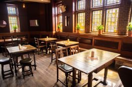 Tables, chairs, plants and windows at the Duke of Edinburgh, Brixton independent pub near Clapham, South West London