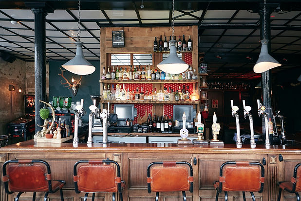 Bar with stools and beer taps at Lord Morpeth, independent Bow pub in London.